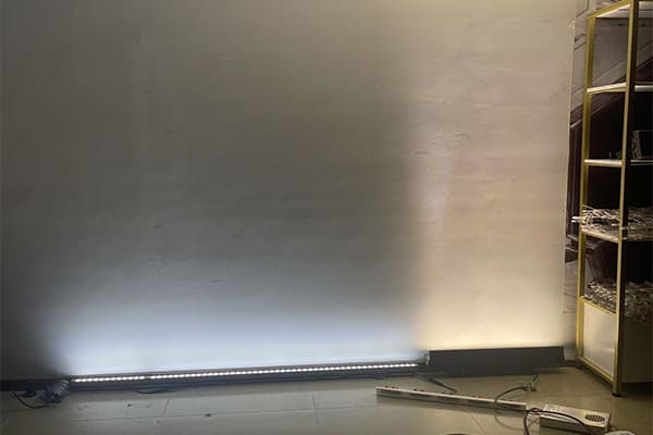 Asymmetrical beam angle for a wall washer light